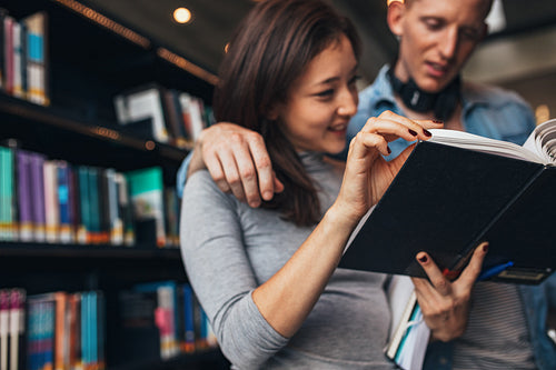 Students reading a book in a library