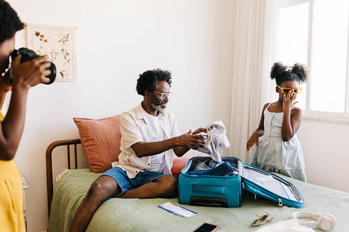 Girl posing for her mom's camera during a travel packing moment at home