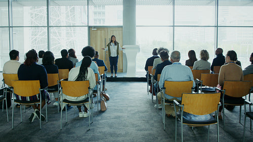 Woman giving a professional business presentation to a diverse audience