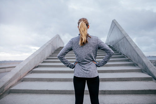 Young woman standing by steps outdoors