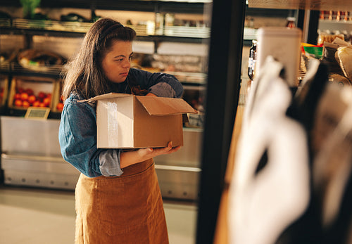 Grocery store employee with Down syndrome restocking food products