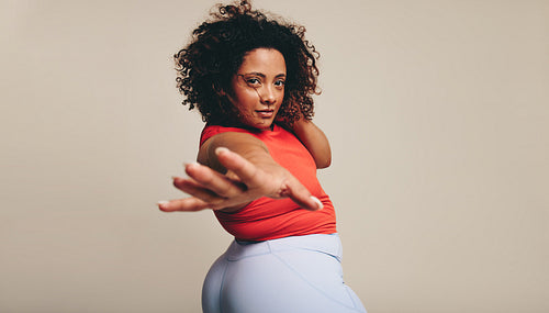 Woman looking at the camera as she moves her body expressively in a studio