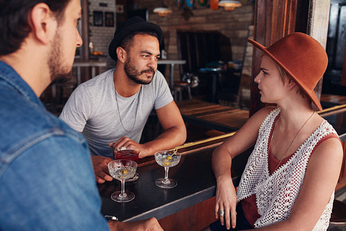 Young men and women meeting in a coffee shop and discussing