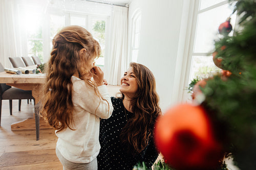 Mother pampering her child while celebrating Christmas.
