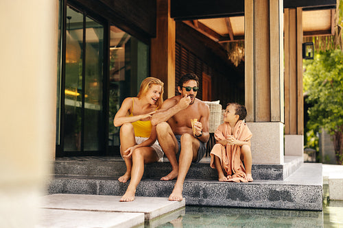 Happy parents and son enjoy ice cream at luxury villa