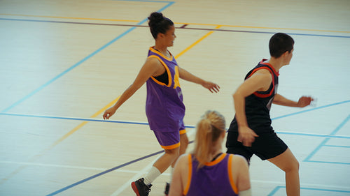 Young athletes playing basketball on court