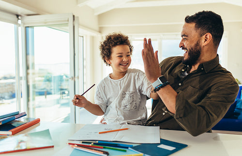 Father and son having fun while doing homework