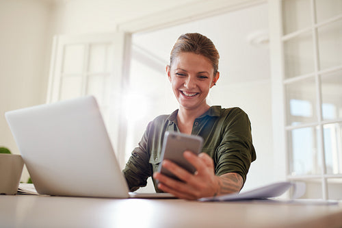 Woman using smart phone and smiling