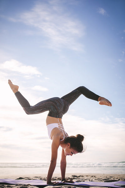 Female exercising yoga on the sea shore