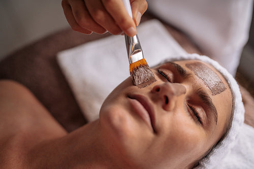 Beautiful woman with facial mask at beauty salon