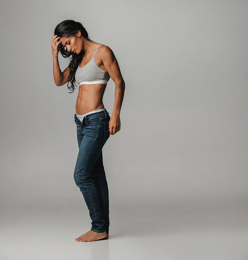 Fit young woman with hand on head looking at feet