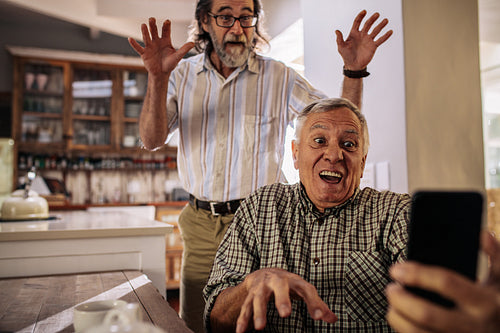 Retired men making funny faces while taking selfie