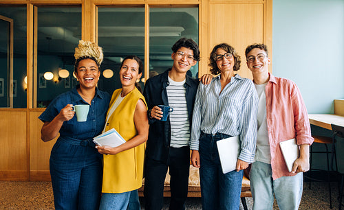 Group of young adults posing together in a casual office environment