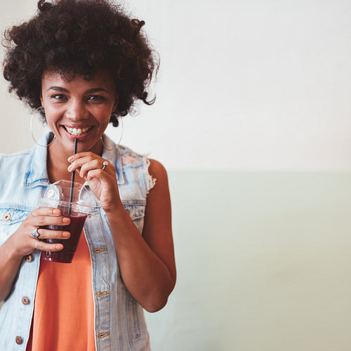 Happy young woman having a fresh fruit juice