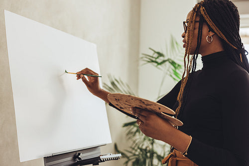 Female painter drawing on a canvas