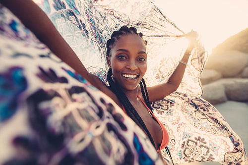 Woman on beach with scarf in the breeze