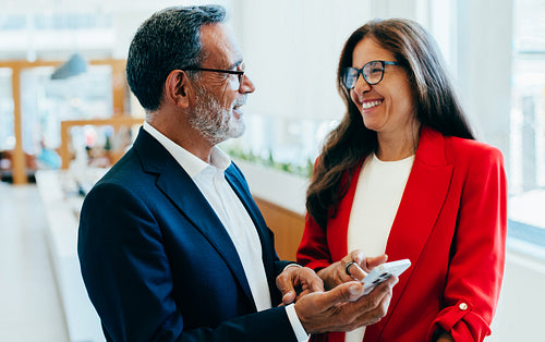 Senior business professionals sharing ideas during a friendly conversation in an office