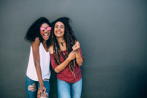Women standing against a wall and posing
