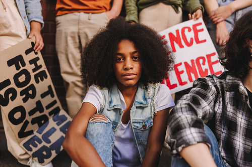 Black teenage girl sitting with a group of youth peace activists