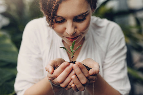 Woman smelling small plant in garden center