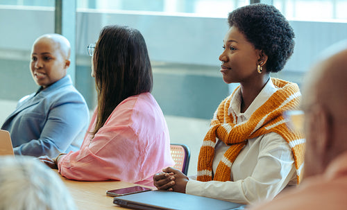 Diverse professionals engaged in a board meeting discussion at a modern office