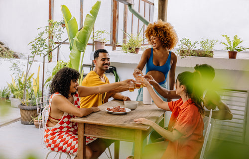Friends toasting drinks at a summer gathering on a patio