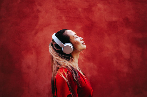 Woman finds calm listening to music with headphones in studio portrait