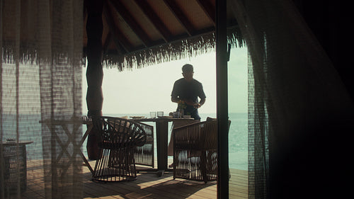 Resort staff preparing a luxurious breakfast on an overwater villa at an island resort