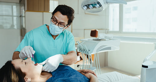 Dentist performing a dental checkup on an adult patient
