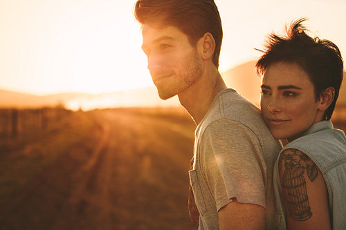 Woman embracing a man outdoors on a road trip