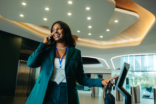 Confident businesswoman talking on phone in a modern office lobby