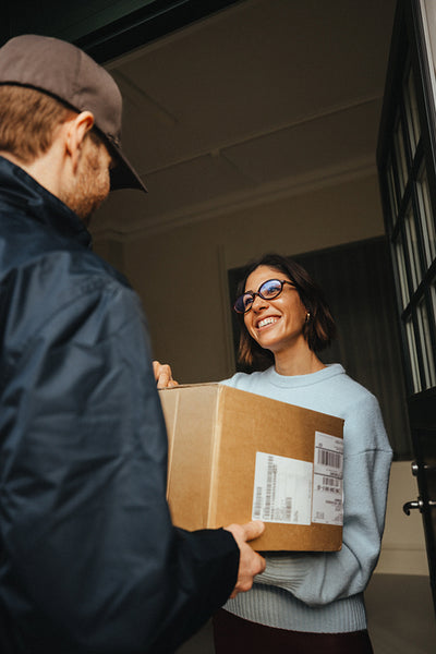 Woman and courier complete a delivery with a package at the office entrance