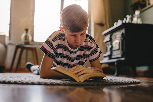 Kid lying on floor and reading book