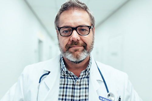 Mature male medical doctor standing in hospital