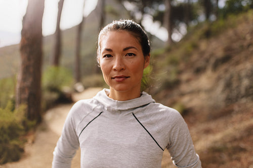 Woman runner standing outdoors on country road