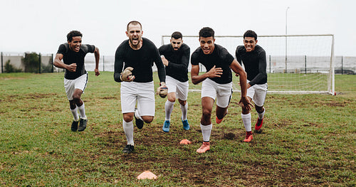 Football players celebrating victory running on field