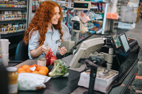 Cashier scanning grocery products at checkout