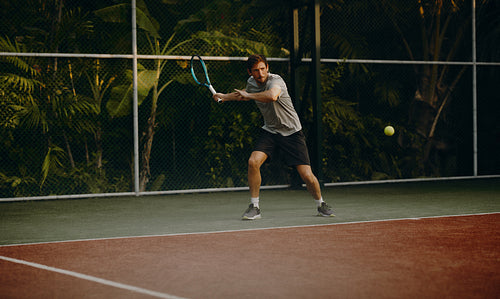 Male tennis player hitting a forehand