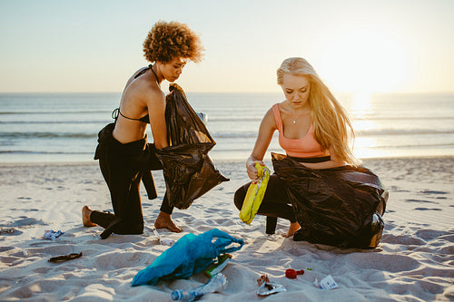 Girls picking up trash from the beach