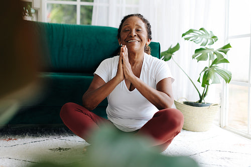 Yoga for seniors: Mature woman practicing meditation in prayer pose
