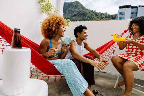 Friends relaxing in hammocks with drinks on a rooftop in Rio de Janeiro