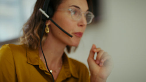 Businesswoman in headset talking on video call in modern office