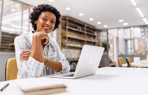 Ethnic online store owner smiling at the camera in a warehouse