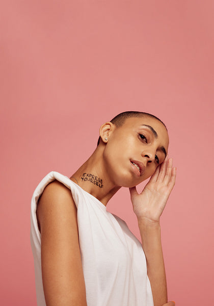 Woman with shaved head posing in studio