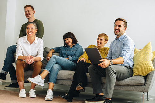 Happy creative team sitting in lobby