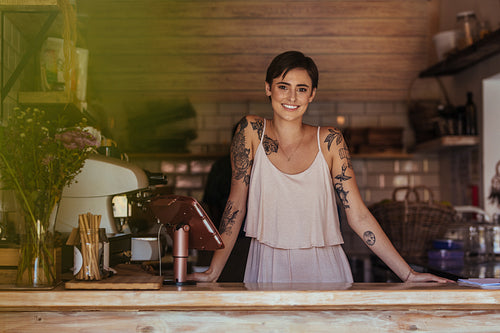 Woman entrepreneur standing at the counter of her cafe