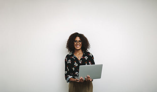 Portrait of a smiling businesswoman in office holding a laptop