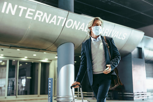 Business traveler with face mask at airport