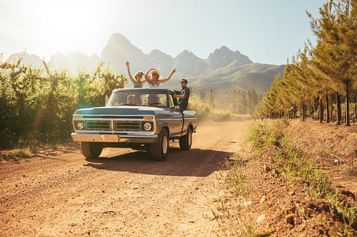 Friends in the open back of a vintage truck on a summer day