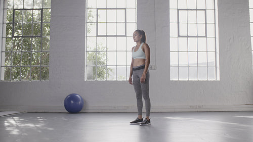 Woman doing burpee workout at fitness studio